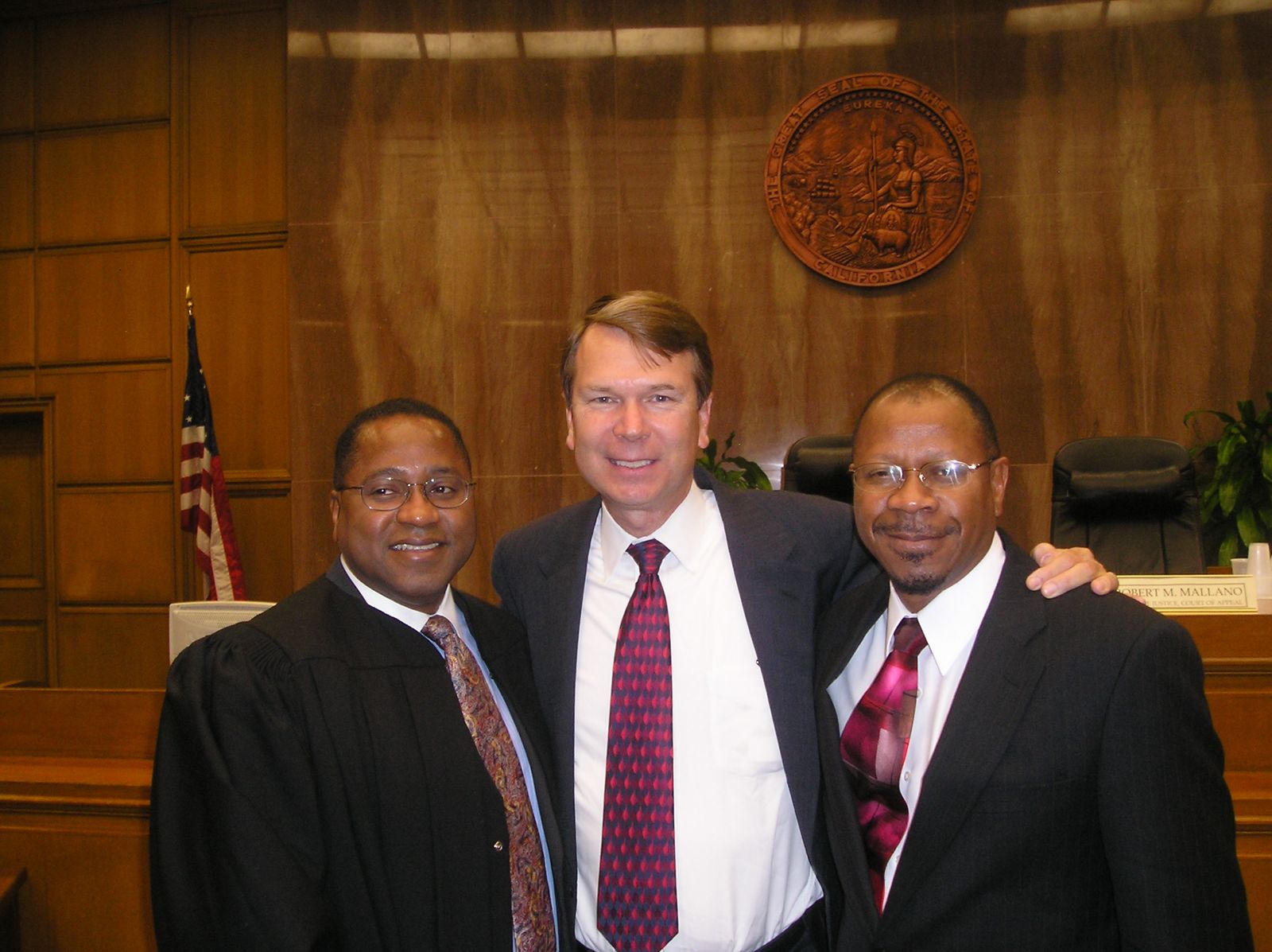 Victor Wright in judicial robes, with Steve Hauser and another man, in a courtroom
